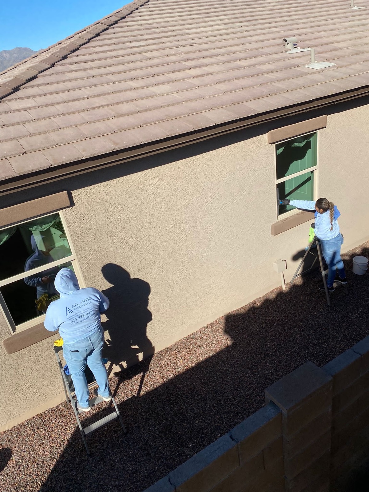 Two team members cleaning exterior windows